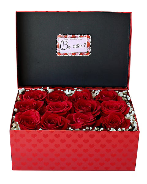 Red roses in a box with a 'Be mine?' card
