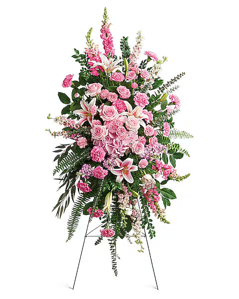 Floral arrangement with pink and white flowers on a stand against 