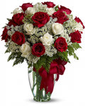 Bouquet of red and white roses in a vase with a red ribbon 