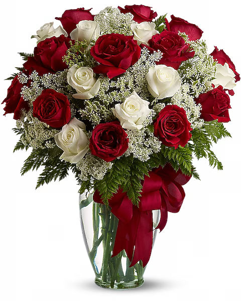 Bouquet of red and white roses in a vase with a red ribbon 