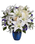 Bouquet of white lilies and roses with greenery in a blue vase