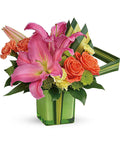 Colorful flower arrangement with pink lilies and orange roses in a green vase
