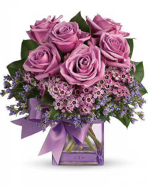 Bouquet of pink roses with a purple ribbon in a clear vase